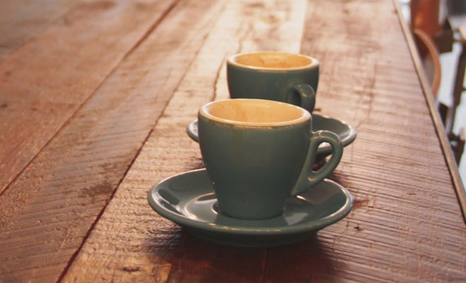 Twee koffietassen op een houten tafel